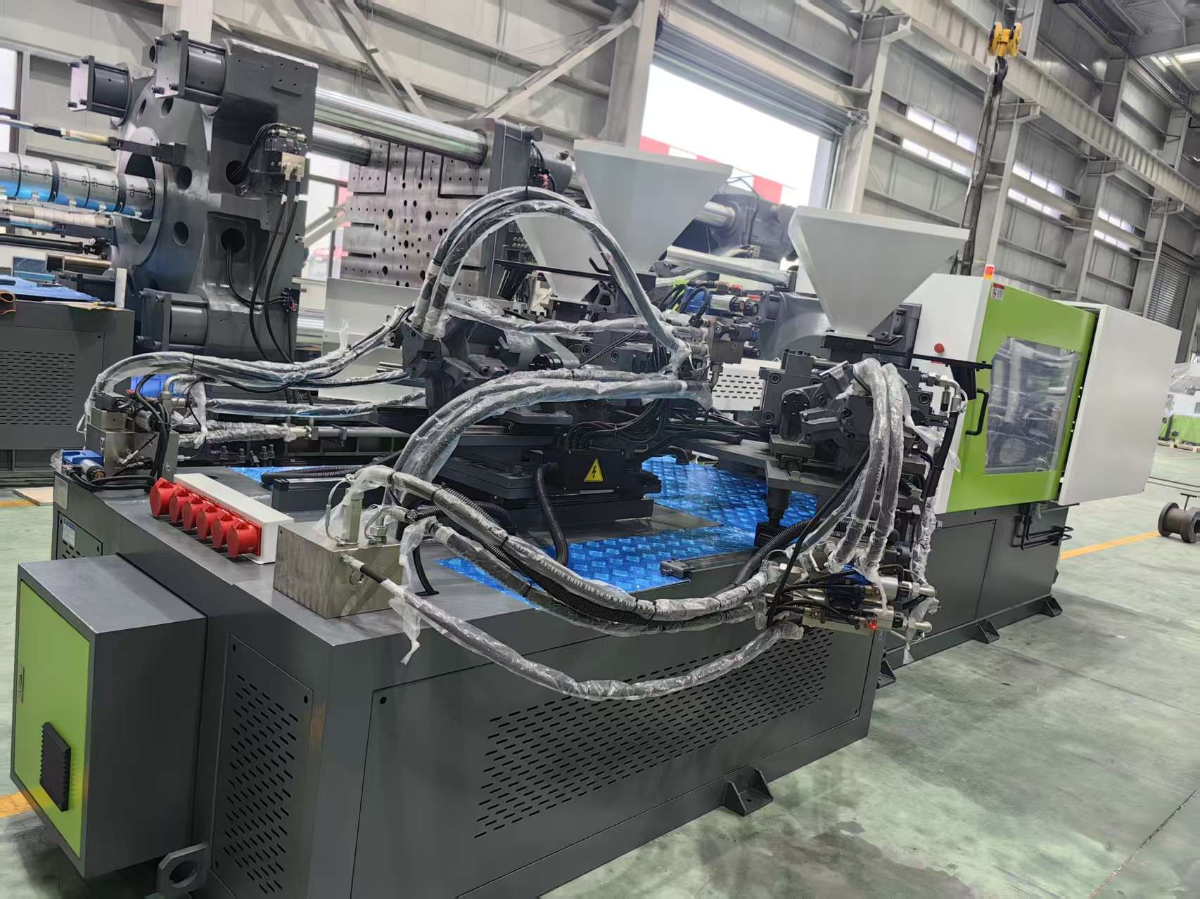 Three-Color Injection Molding Machine A state-of-the-art three-color injection molding machine in a clean factory setting.
