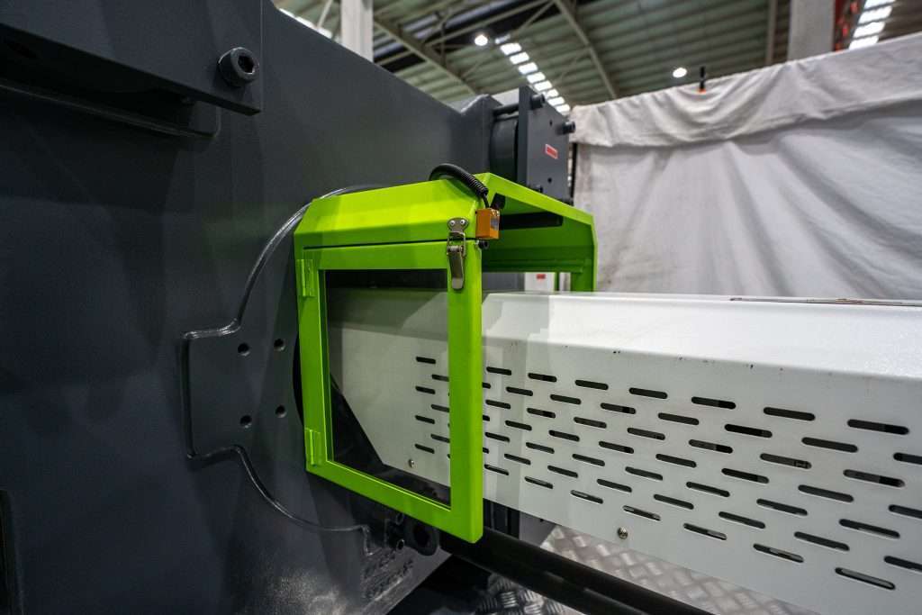 Injection molding machine safety guard and position sensor during factory assembly